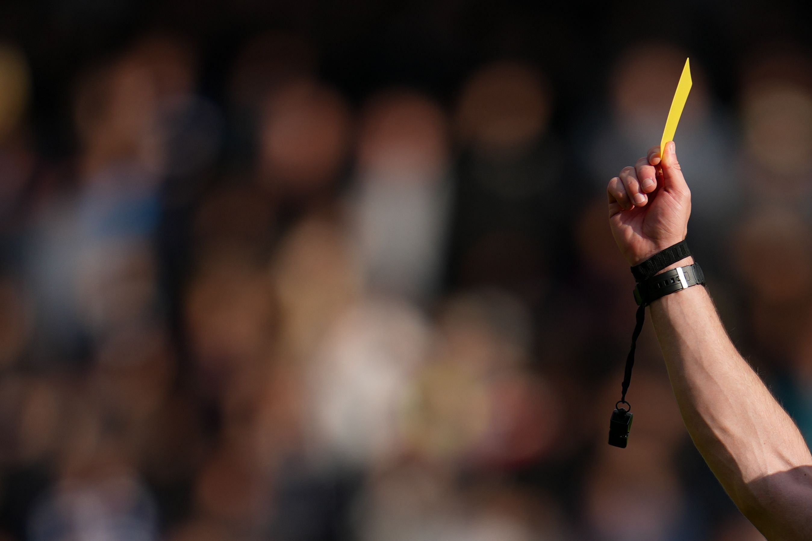 referee holding a yellow card