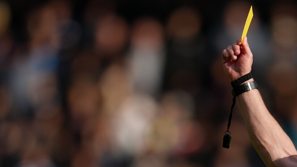 referee holding a yellow card